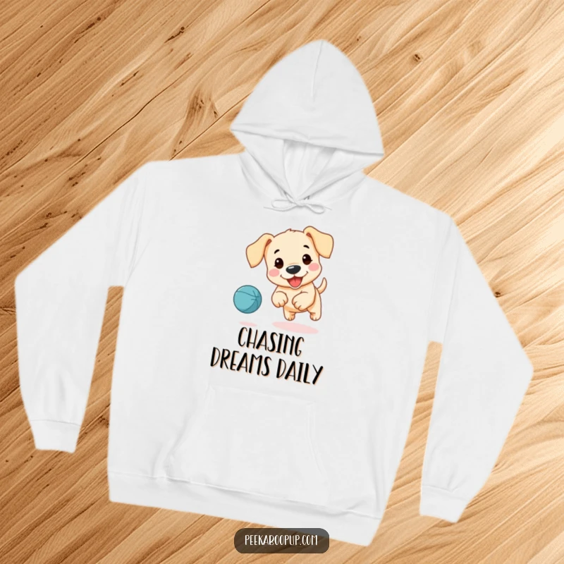 Funny hoodie with a design of a cute, floppy-eared puppy joyfully pursuing a bouncing ball with excitement.