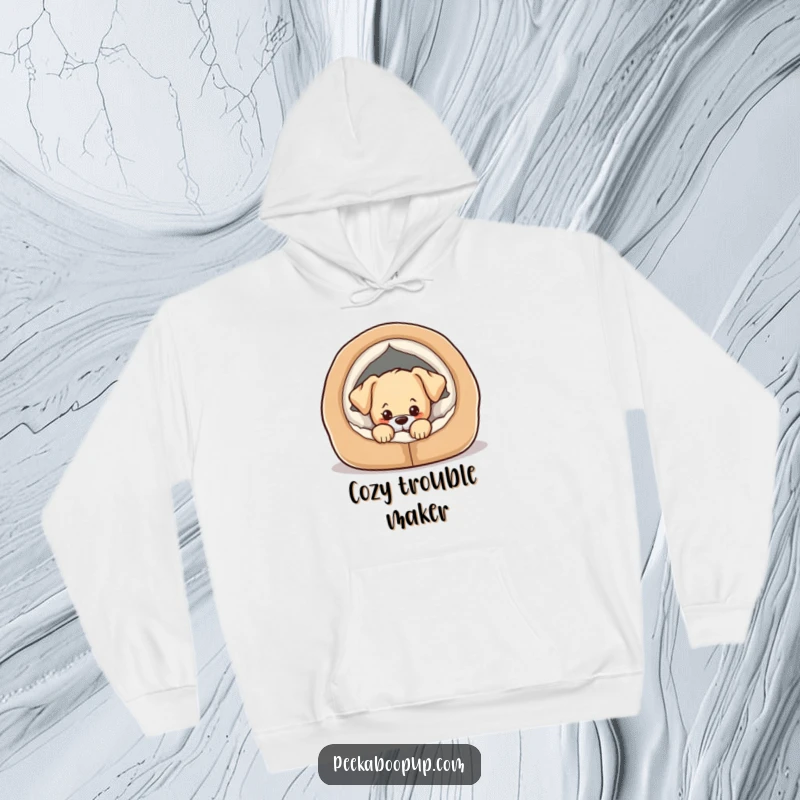 Funny hoodie with a design of a puppy peeking from a comfortable dog bed with a mischievous expression.