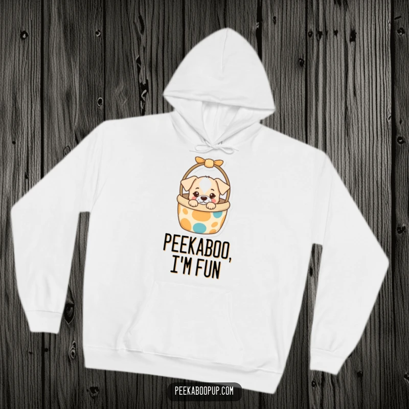 Funny Hoodie showing a curious puppy peeking cheekily from a vibrant dog toy basket, offering humorous warmth and playful charm.