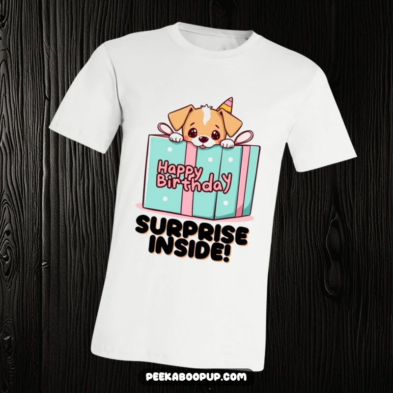 Funny t-shirt featuring a puppy peeking out of a large birthday gift box, embodying playful surprise.